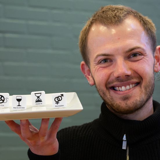 Bibliotekets litteraturformidler Stinus holder en tallerken med spillebrikker