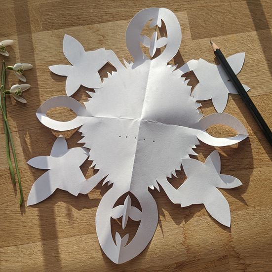 Vintergækker, gækkebrev og saks på et bord