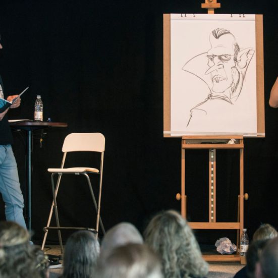 To mænd på en scene, der læser og tegner