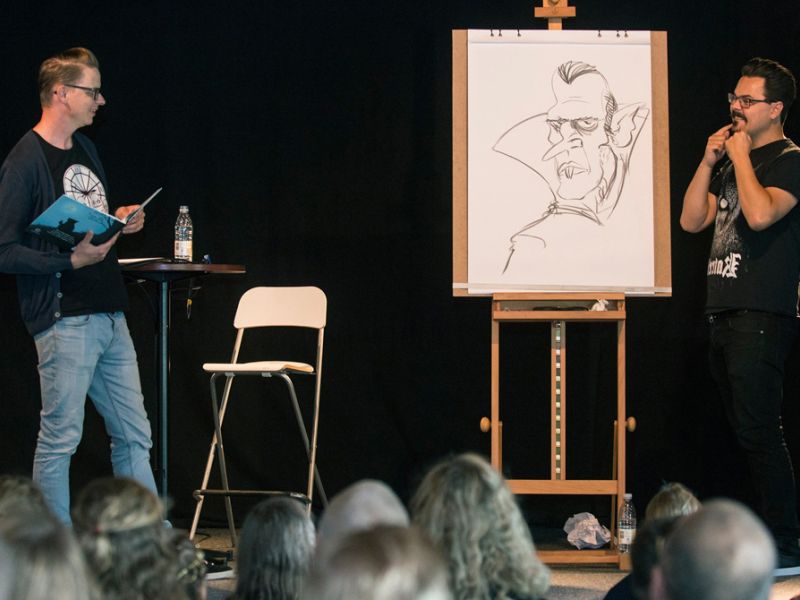 To mænd på en scene, der læser og tegner