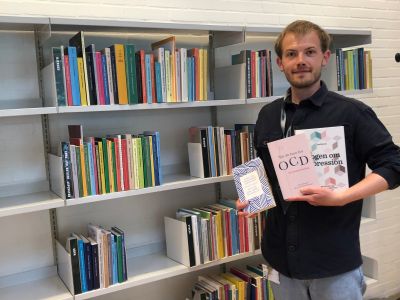 Litteraturformidler der står foran hylderne hvor sundhedsbøgerne står