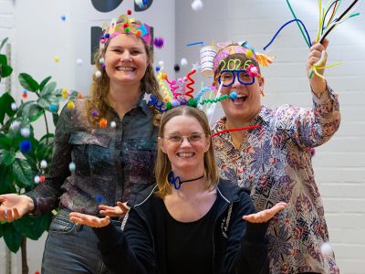 Bibliotekets litteraturformidler Trine, Mette og Louise meed nytårshatte og -briller