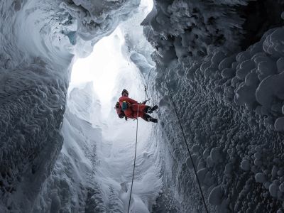 Mand firer sig ned med reb i en isgrotte