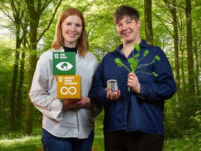 Bibliotekets litteraturformidlere Mette og Louise står foran en grøn bøgeskov