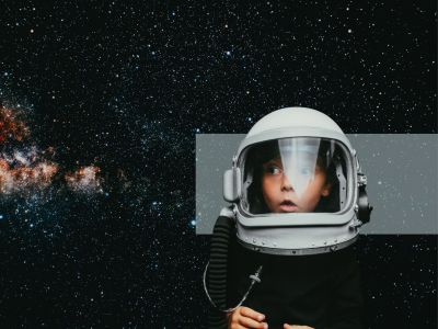 Barn med astronautudstyr ser op med mod en baggrund af stjerner.