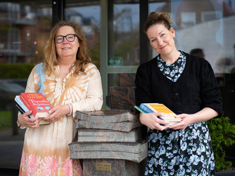 Bibliotekets medarbejdere Susan og Kamilla foran biblioteket