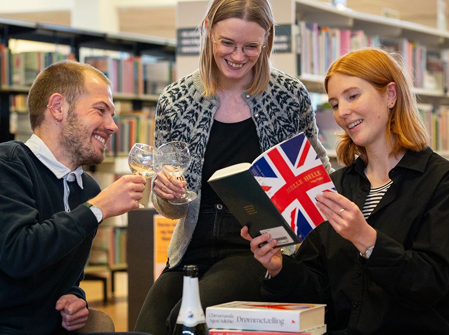 Bibliotekets litteraturformidlere skåler og kigger i en bog