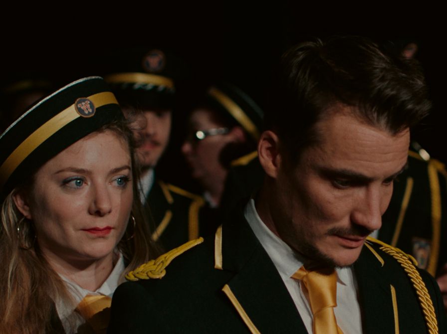 en mand i forgrunden, en kvinde bag ham, resten af et band bag dem